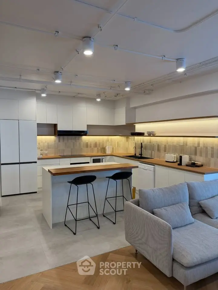 Modern open-layout kitchen with sleek design and cozy living area