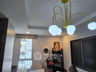 Modern living room with unique chandelier and cozy seating area