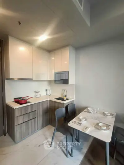 Modern kitchen with sleek cabinetry and dining area, featuring a compact and efficient layout.