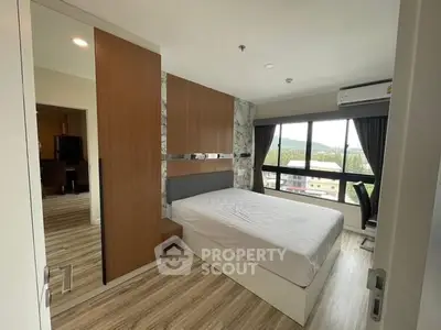 Modern bedroom with large window and wooden accents, offering a serene view.