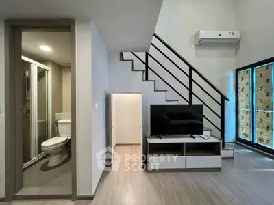 Modern duplex interior with sleek staircase and compact bathroom