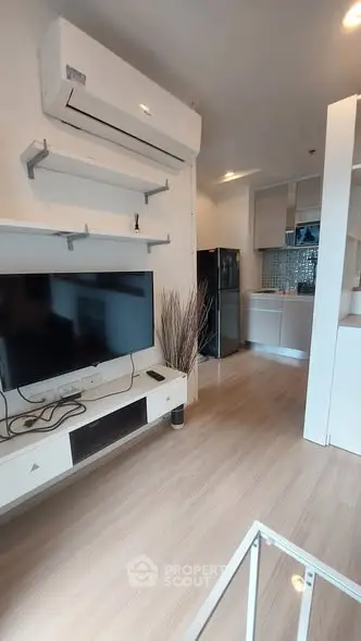 Modern living room with sleek TV setup and open kitchen layout