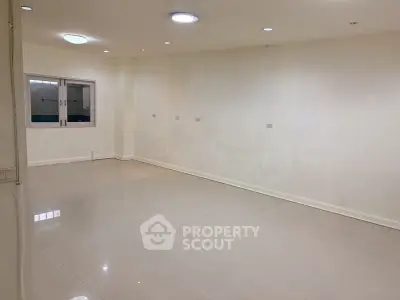 Spacious empty room with tiled flooring and recessed lighting, ready for customization.