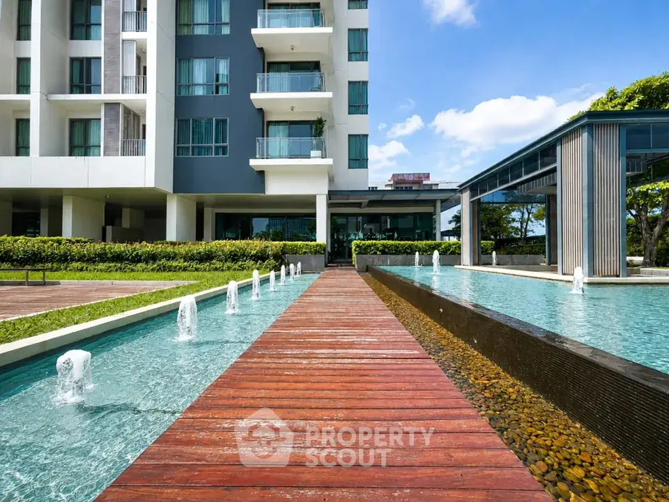 Modern apartment building with elegant water feature and lush landscaping