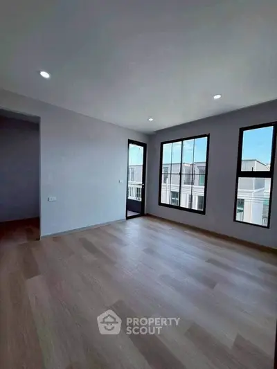 Spacious modern living room with large windows and wooden flooring