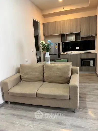 Modern open-layout living room with cozy sofa and stylish kitchen area