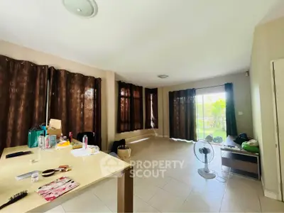 Spacious living room with large windows and garden view, ideal for modern living.