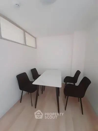 Cozy study room with modern table and chairs, perfect for focused work or meetings.