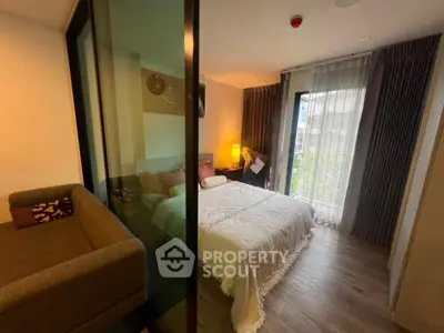 Modern bedroom with glass partition and cozy decor in a stylish apartment.