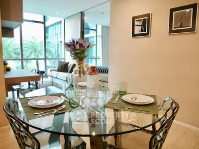 Modern dining area with glass table and stylish decor in a bright apartment with large windows.