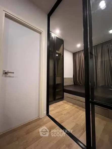 Modern bedroom with sleek glass sliding doors and wooden flooring