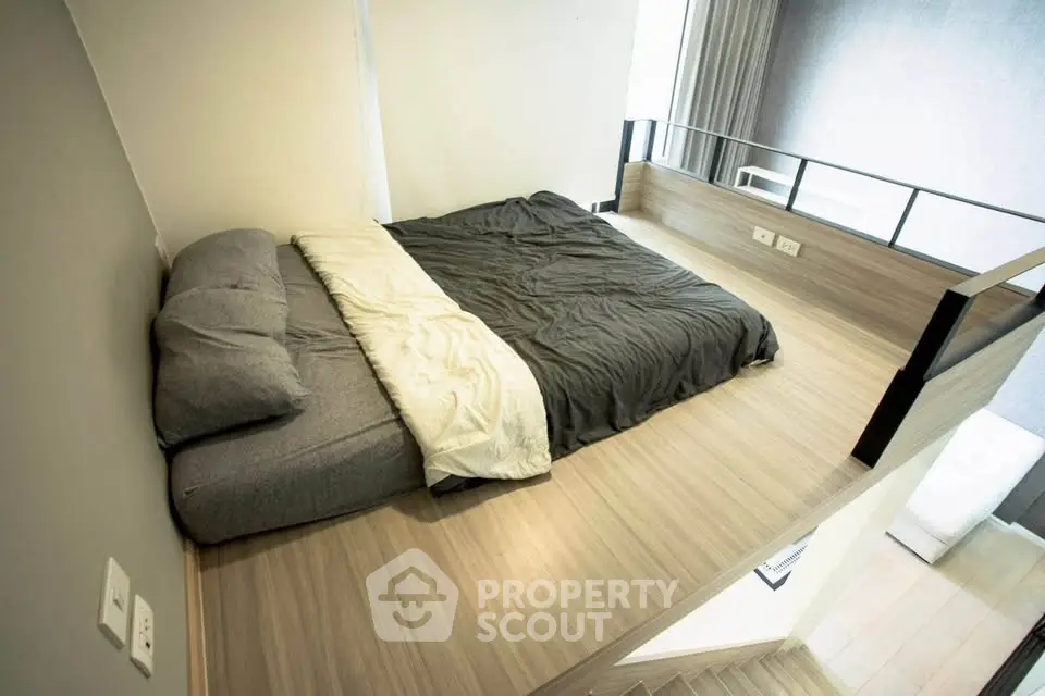 Modern loft bedroom with minimalist design and cozy bedding in a stylish apartment.