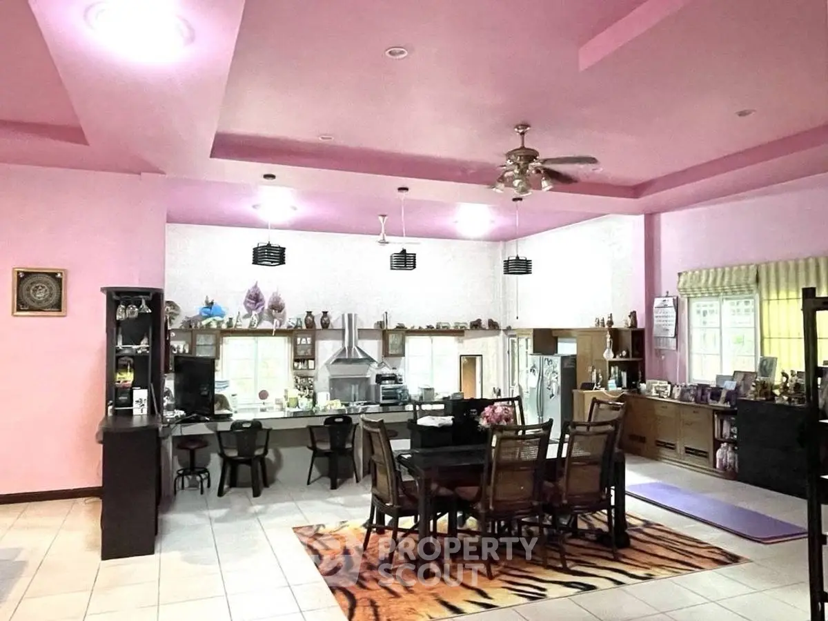 Spacious open-plan kitchen and dining area with vibrant pink walls and modern amenities.