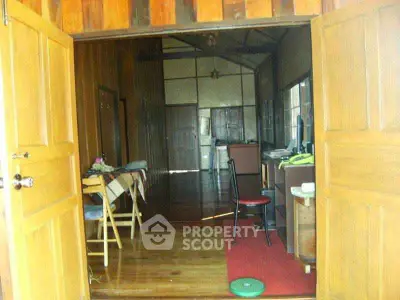 Charming rustic interior with wooden floors and walls, featuring a cozy workspace and dining area.