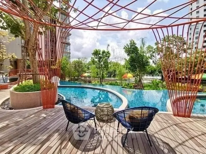Luxurious poolside area with modern seating and lush greenery, perfect for relaxation and leisure.