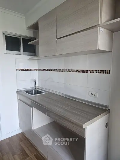 Modern minimalist kitchen with sleek cabinetry and tiled backsplash