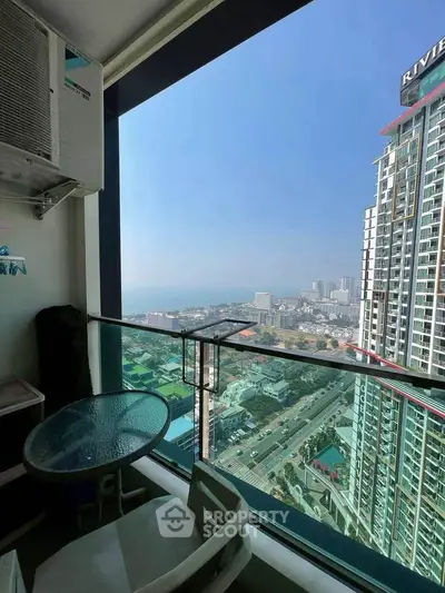Stunning high-rise balcony view with cityscape and ocean horizon, perfect for urban living enthusiasts.