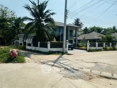 Charming suburban home with lush greenery and spacious driveway in a serene neighborhood.