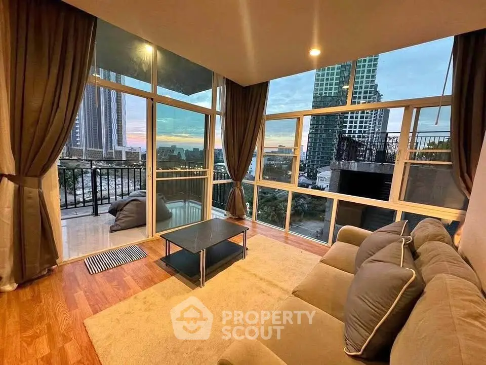 Spacious living room with stunning city view and large windows.