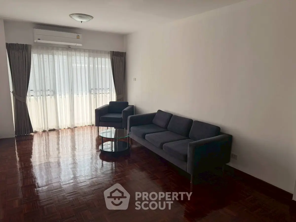 Spacious living room with modern furniture and large window for natural light.