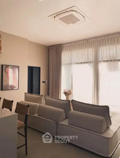 Modern living room with stylish sofa and large windows offering natural light