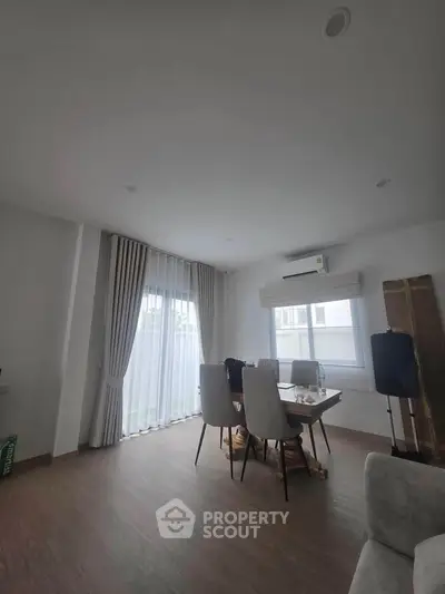 Modern dining area with natural light and elegant curtains in a stylish apartment.