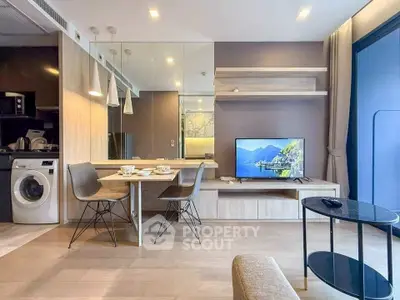 Modern living room with stylish furniture, wall-mounted TV, and integrated kitchen appliances in a cozy apartment.