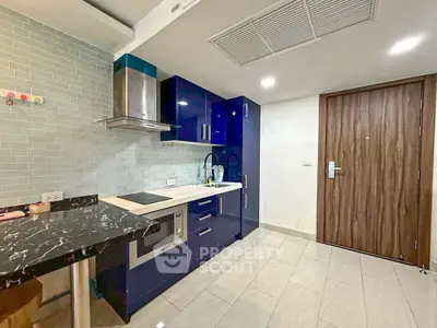 Modern kitchen with sleek blue cabinets and marble countertop