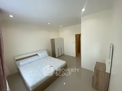 Spacious bedroom with modern furniture and ample natural light