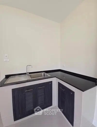 Modern kitchen with sleek black countertops and stainless steel sink