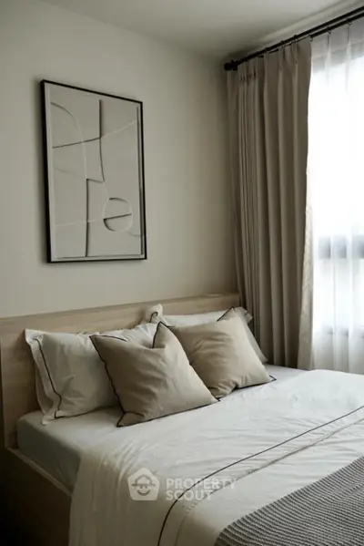 Cozy bedroom with modern decor and natural light, perfect for relaxation.