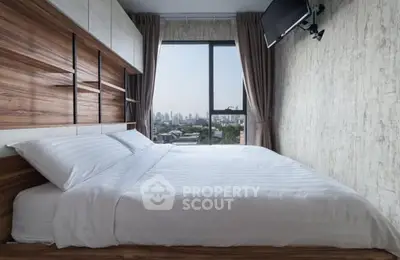 Modern bedroom with city view and wall-mounted TV, featuring stylish wood paneling.