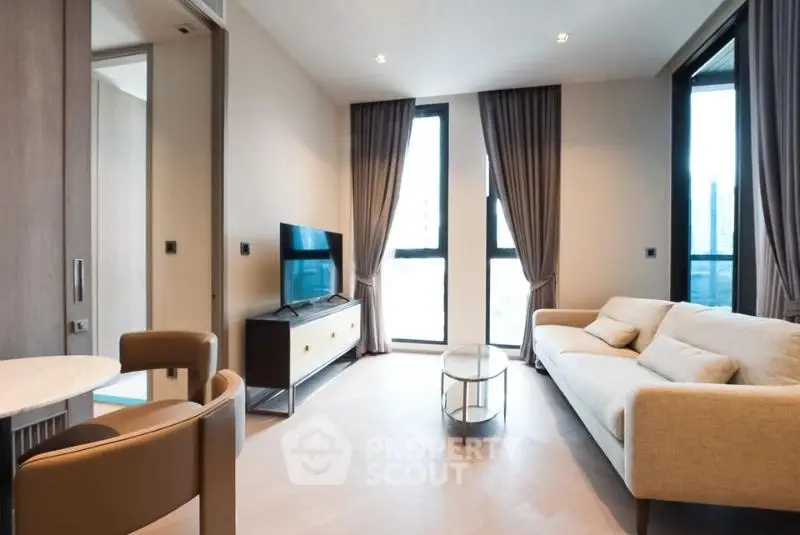 Modern living room with stylish furniture and large windows in a contemporary apartment.