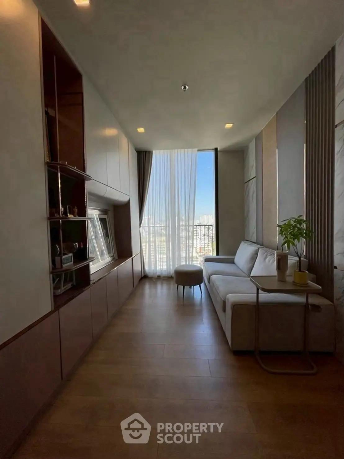 Stylish living room with large window and modern decor in urban apartment.