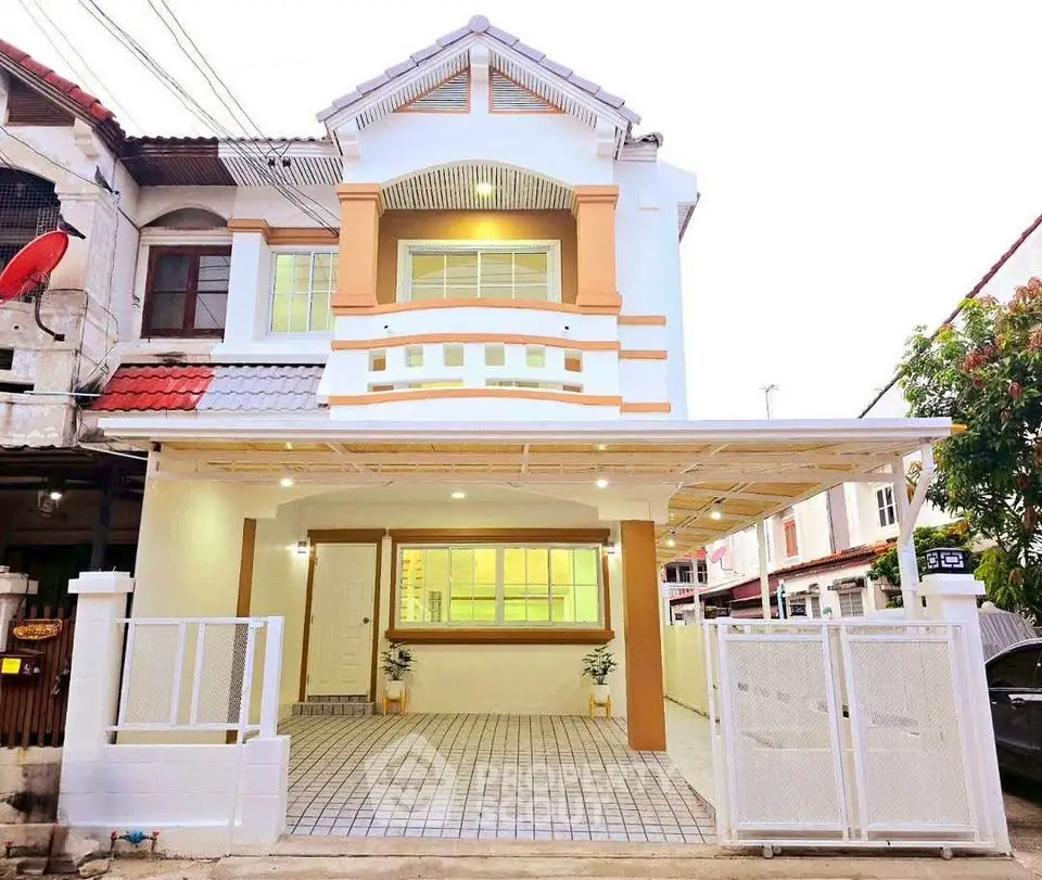 Charming two-story house with modern facade and spacious gated driveway in a serene neighborhood.
