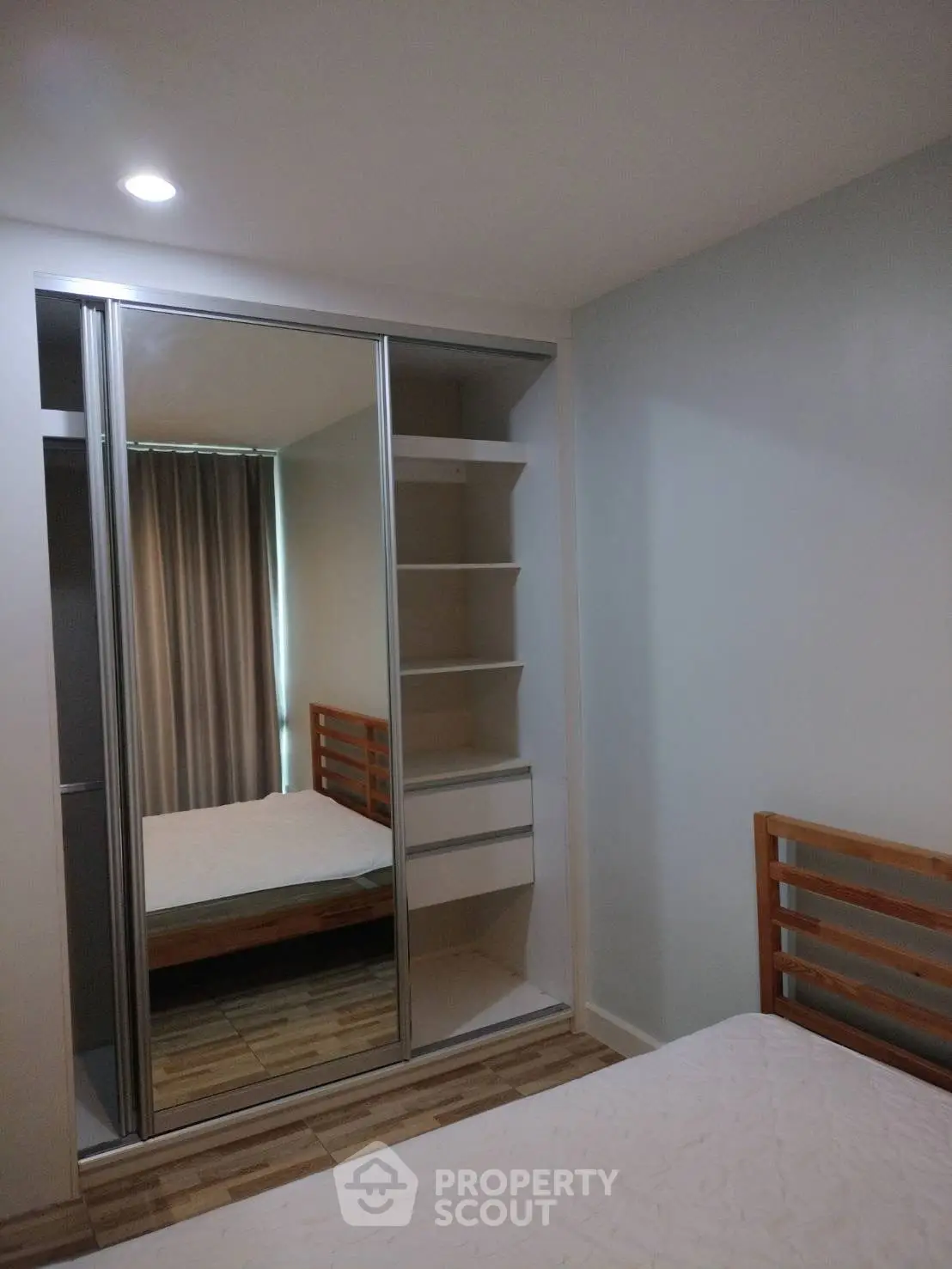 Modern bedroom with mirrored closet and wooden bed frame