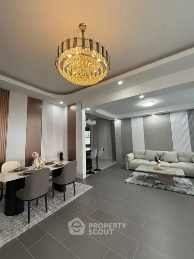 Luxurious modern living room with elegant chandelier and stylish dining area