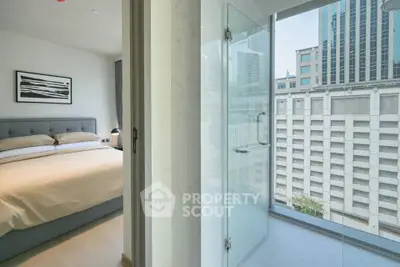 Modern bedroom with ensuite bathroom and city view in luxury apartment