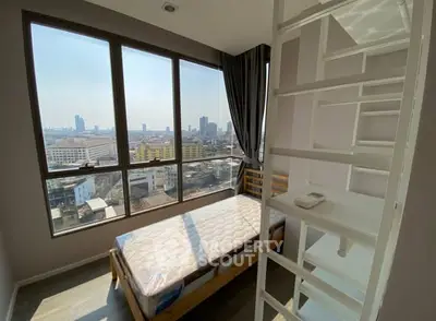 Modern bedroom with loft bed and panoramic city view through large windows.