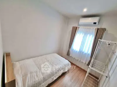 Cozy minimalist bedroom with natural light and air conditioning