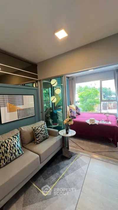 Modern living room with cozy sofa and stylish decor leading to a bright bedroom with large window view.