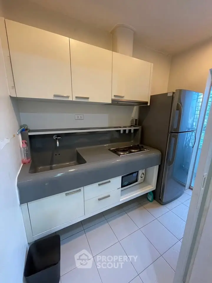 Modern kitchen with sleek cabinetry and stainless steel appliances in a compact layout.