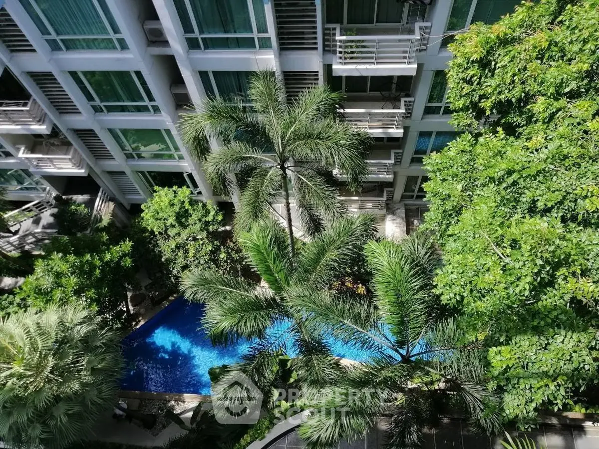 Luxurious apartment building with lush greenery and inviting pool view