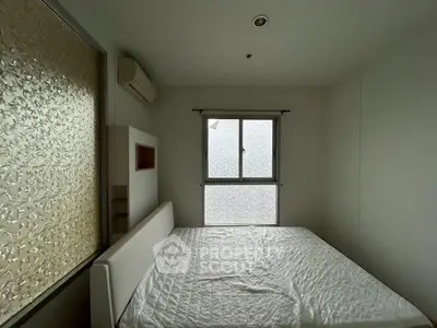 Cozy bedroom with large window and air conditioning, perfect for restful nights.