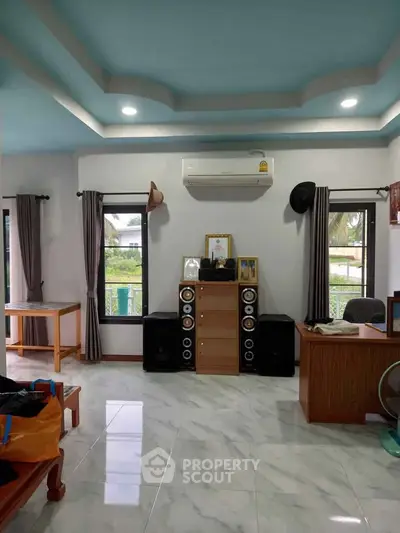 Spacious living room with modern decor and large windows offering natural light.