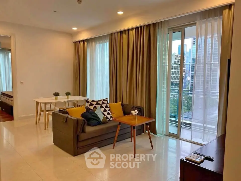 Spacious modern living room with balcony and city view, featuring stylish decor and ample natural light.