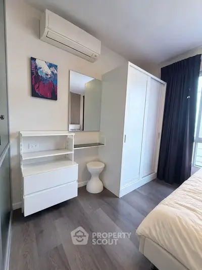 Modern bedroom with sleek white furniture and air conditioning unit