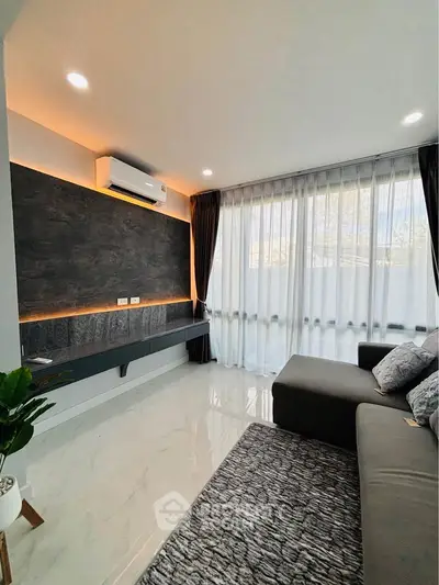 Modern living room with sleek design, large windows, and cozy seating area.
