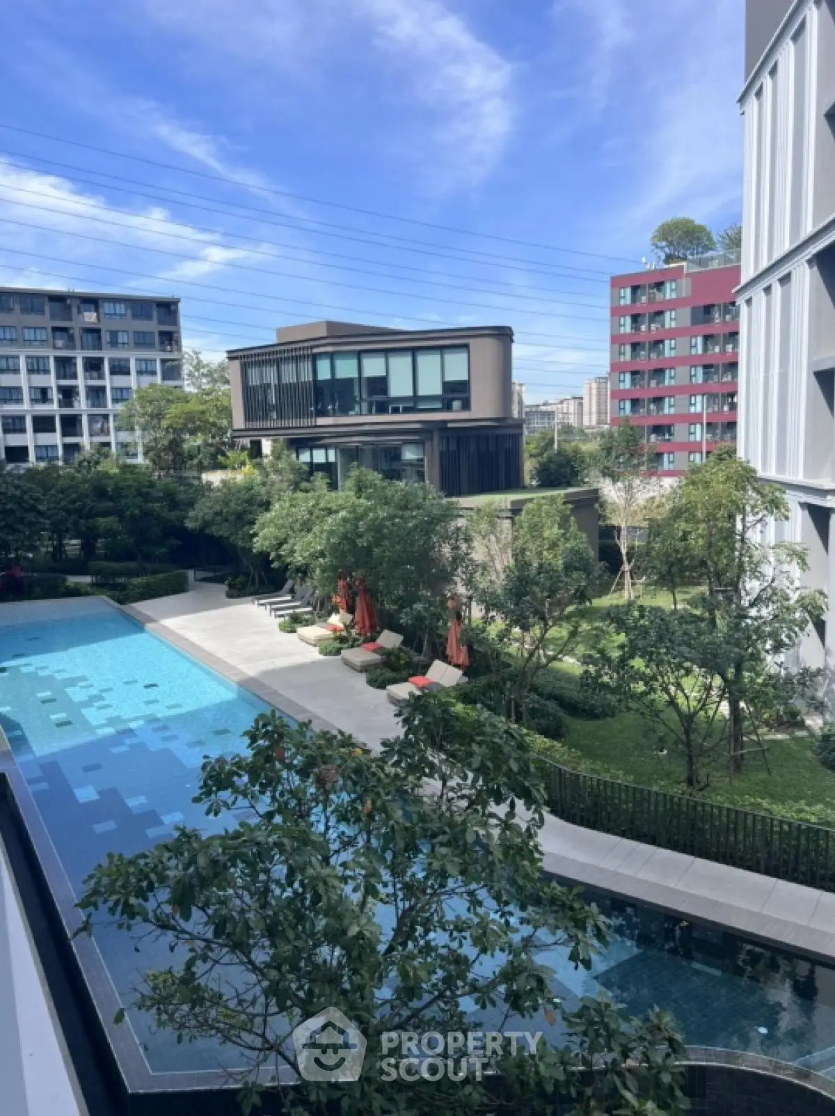Luxurious residential complex with modern pool and lush garden view