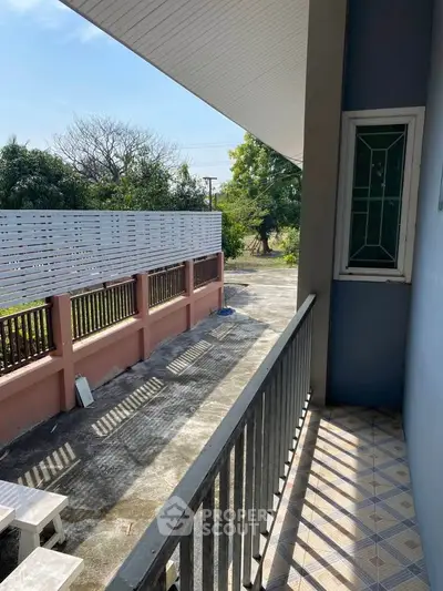 Charming balcony with tiled floor and garden view, perfect for relaxation.